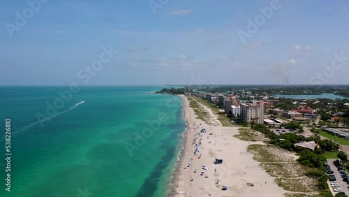 Drone view of a beach in Venice, FL with ocean waves crashing the shore with residential buildings photo
