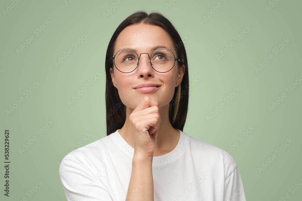 Closeup of woman dressed in white T-shirt, wearing spectacles and dreaming about something pleasant Closeup of woman dressed in white T-shirt, wearing spectacles and dreaming about something pleasant