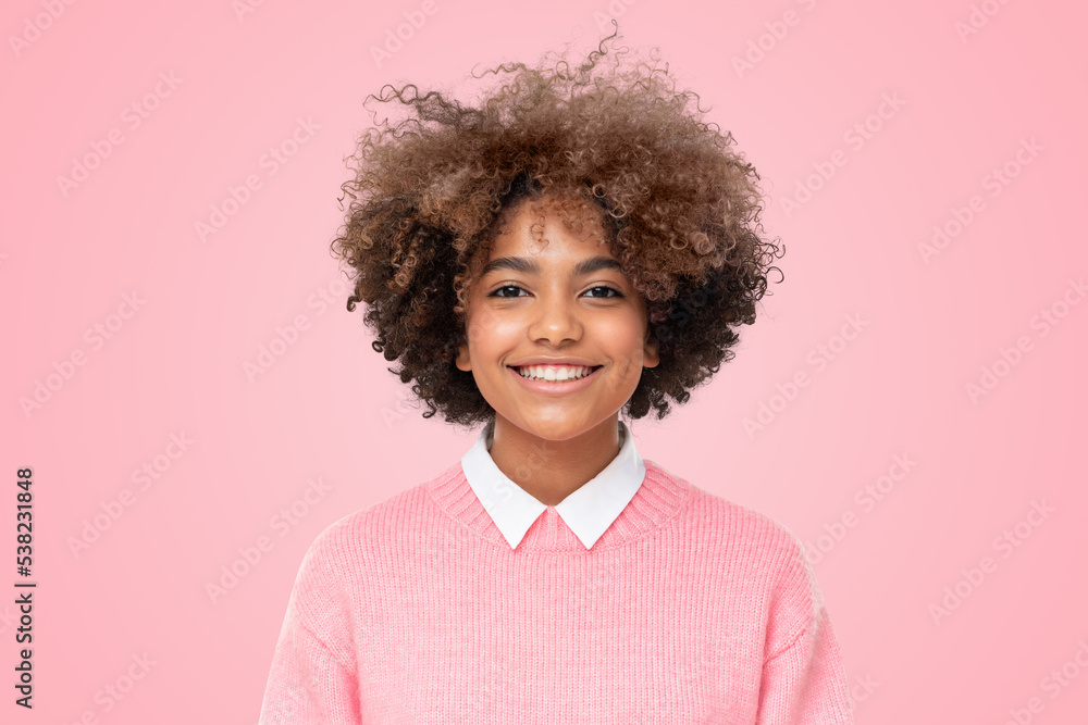 Studio portrait of smiling african teen girl with curly hairstyle isolated on pink background Studio portrait of smiling african teen girl with curly hairstyle isolated on pink background