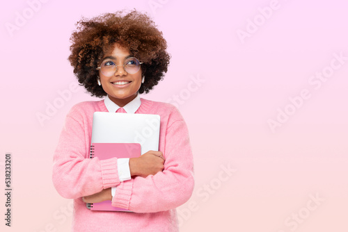 Studio portrait of african american student teen girl, holding laptop, dreaming about holidays