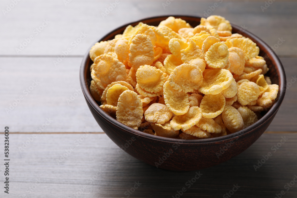 Bowl of tasty crispy corn flakes on wooden table, closeup Bowl of tasty crispy corn flakes on wooden table, closeup