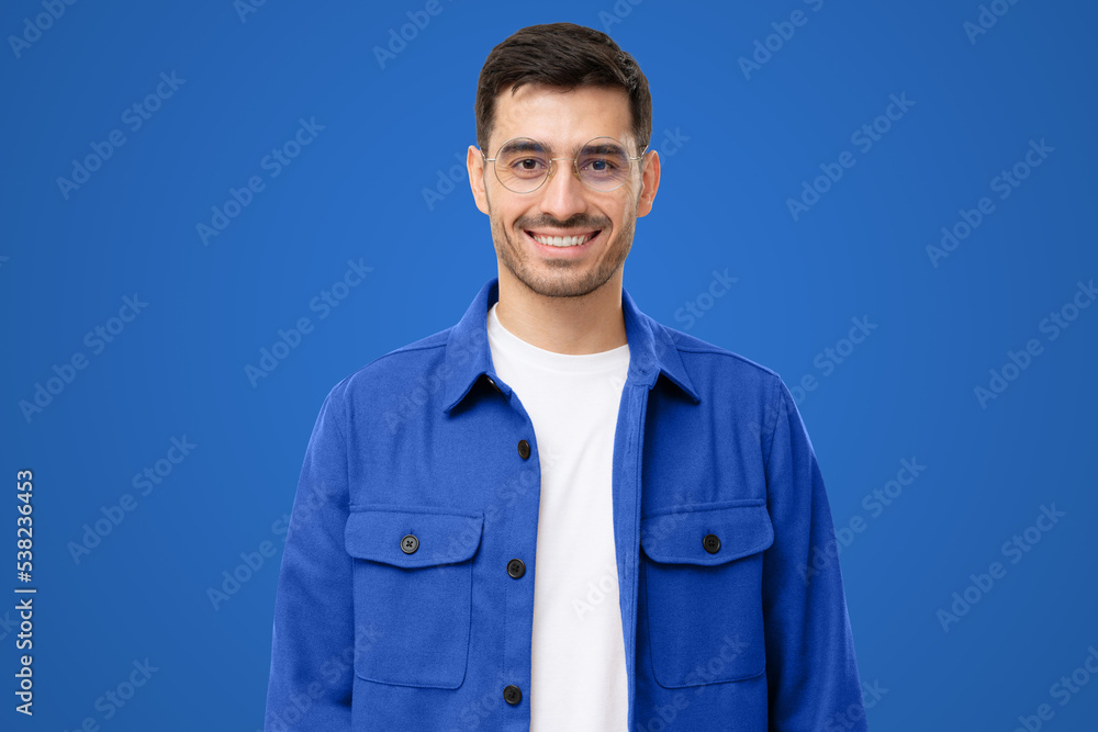 Portrait of young male teacher in round glasses and casual blue shirt looking at camera Portrait of young male teacher in round glasses and casual blue shirt looking at camera