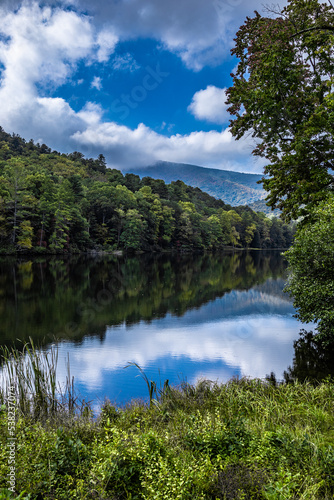 Fototapeta Naklejka Na Ścianę i Meble -  amazingly beautiful Spring or Summer day in the Smoky Mountains with trees reflecting in lake water at Vogel state park, Georgia with vertical frame	