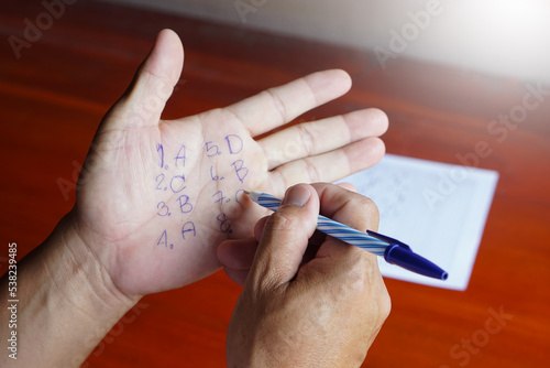 Foto Closeup student's hand writes answer on palm