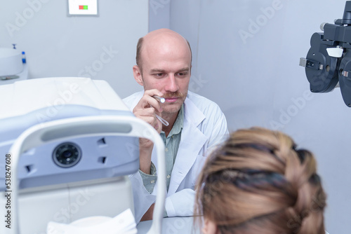 The doctor ophthalmologist examines the patient's eyes.