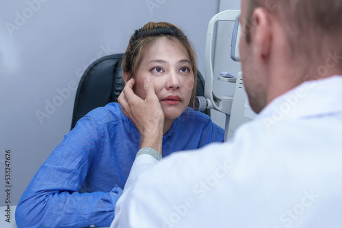 The doctor ophthalmologist examines the patient s eyes.
