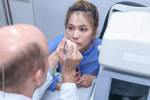 The doctor ophthalmologist examines the patient's eyes.