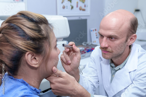 The doctor ophthalmologist examines the patient's eyes.