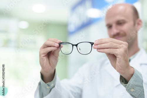 male ophthalmologist with eyeglasses in clinic, closeup. Space for text