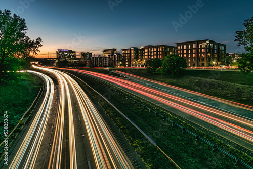 Cuadro en lienzo Skyline of Durham, NC USA with heavy traffic on a highway in the foreground, at the blue hour