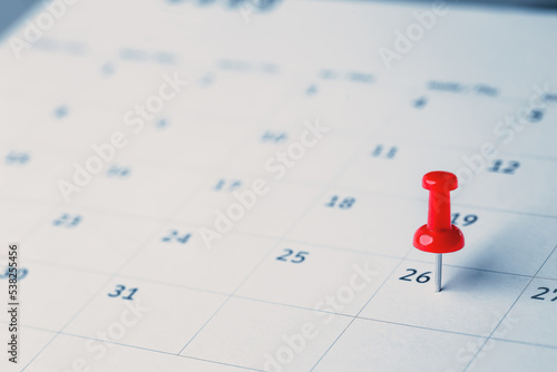 Embroidered red pins on a calendar event Planner calendar,clock to set timetable organize schedule,planning for business meeting or travel planning concept.