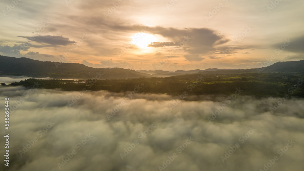 Mountains in fog at beautiful autumn in Phetchabun Thailand. Fog mountain valley, low clouds, forest, colorful sky with.  pine trees in spruce foggy forest with bright sunrise