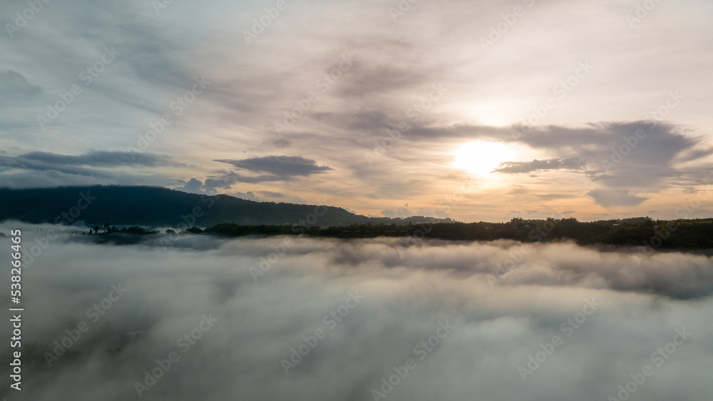 Mountains in fog at beautiful autumn in Phetchabun Thailand. Fog mountain valley, low clouds, forest, colorful sky with. pine trees in spruce foggy forest with bright sunrise Mountains in fog at beautiful autumn in Phetchabun Thailand. Fog mountain valley, low clouds, forest, colorful sky with. pine trees in spruce foggy forest with bright sunrise