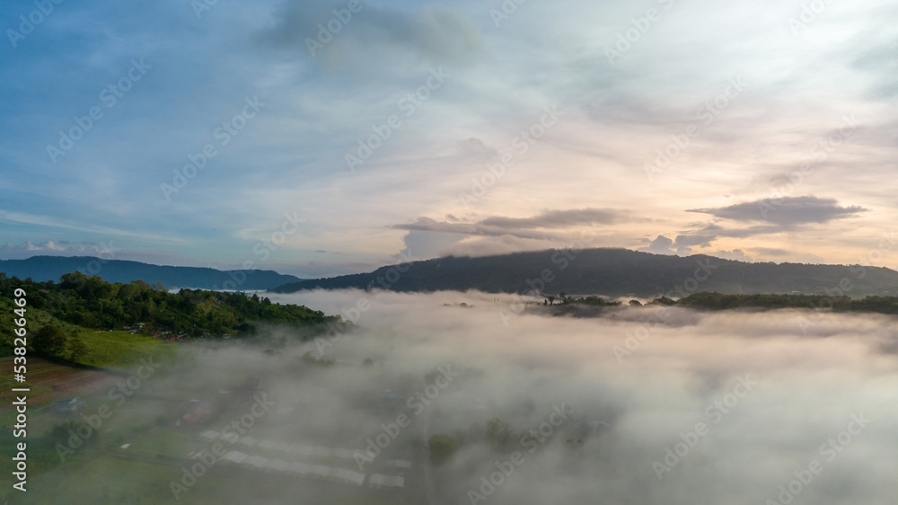 Obraz premium Mountains in fog at beautiful autumn in Phetchabun Thailand. Fog mountain valley, low clouds, forest, colorful sky with. pine trees in spruce foggy forest with bright sunrise