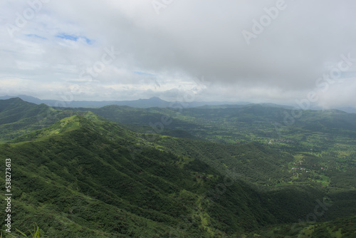 Panoramic landscape view of beautiful lush green Sahyadri mountains in monsoon season as seen from Sinhgad fort located in Pune, Maharashtra, India photo