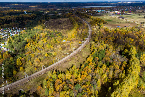 The bend of the railway passing through the forest area and summer cottages, a beautiful landscape from the air