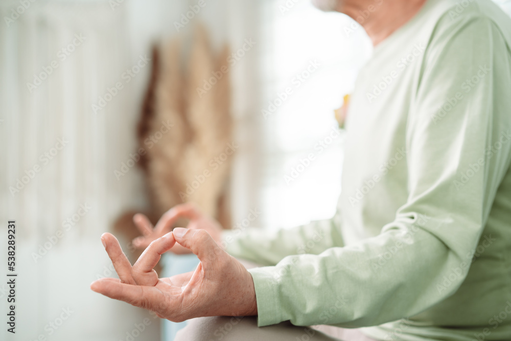 Asian elderly senior old man doing yoga relax in living room at home, Mature retirement happy healthy lifestyle concept..