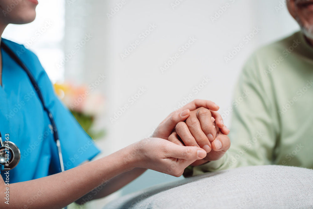 Asian caregiver holding hands senior elderly old male take care mental health care at nursing home.