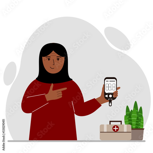 Happy muslim woman holds a glucometer in his hand. The concept of blood sugar control, diabetic.