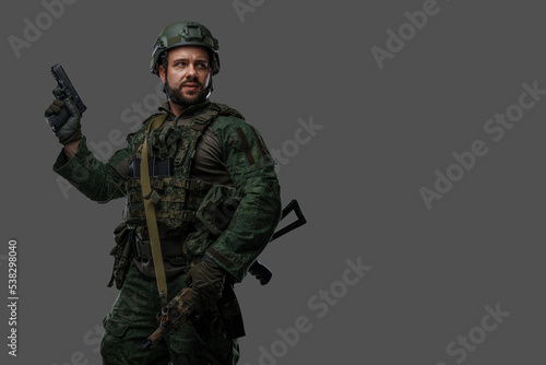 Obraz na plátne Shot of brave russian army soldier dressed in uniform and holding pistol