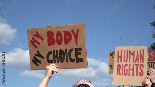 Protesters holding signs My Body My Choice, Human rights, Abortion Is Healthcare, Bans Off Our Bodies. People with placards supporting abortion rights at protest rally demonstration.
