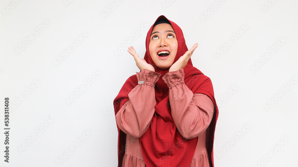 Fall on head. Shocked hijab woman looking up and shout. Studio shot, indoor. Isolated on grey background Fall on head. Shocked hijab woman looking up and shout. Studio shot, indoor. Isolated on grey background