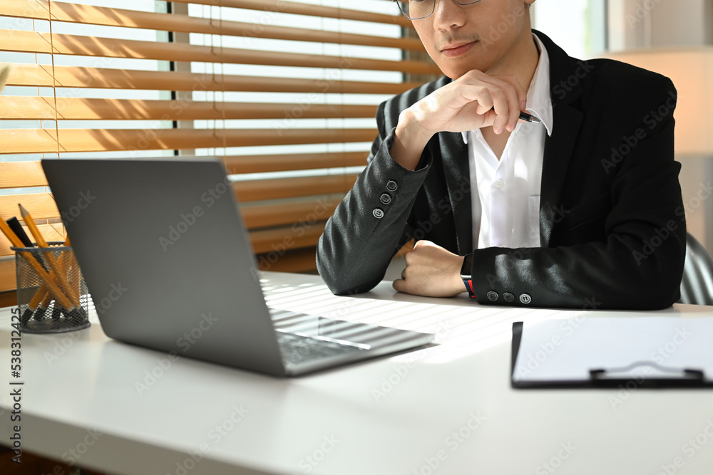 Focused businessman analyzing financial online data on laptop computer screen Focused businessman analyzing financial online data on laptop computer screen