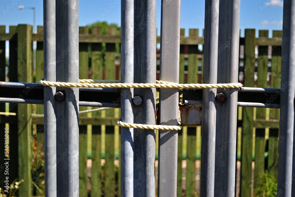 Rope Holding Shut Steel Gates in Close Upon Sunny Day Rope Holding Shut Steel Gates in Close Upon Sunny Day