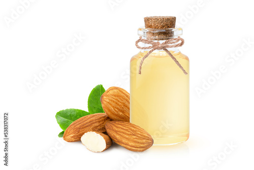 Almond oil in glass bottle and almond nuts with green leaf isolated on white background. photo