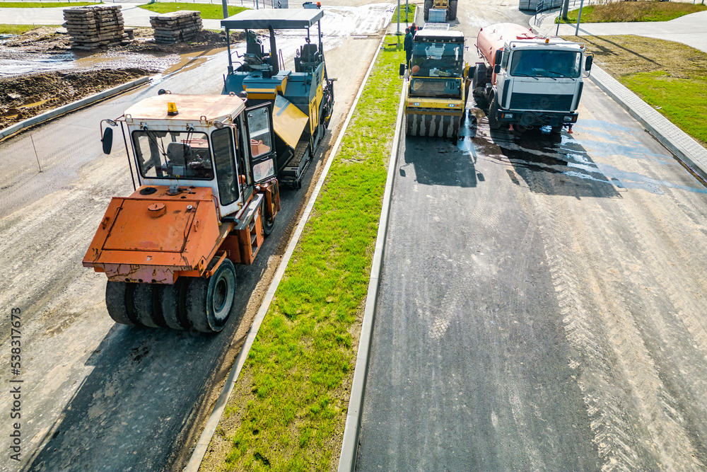 Asphalt laying equipment. Asphalt paver machine on the road repair site. Road renewal process, construction work. View from above. Drone photography. Asphalt laying equipment. Asphalt paver machine on the road repair site. Road renewal process, construction work. View from above. Drone photography.