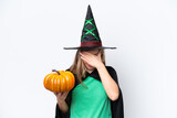 Young blonde woman dressed as a witch holding a pumpkin isolated on white background with tired and sick expression