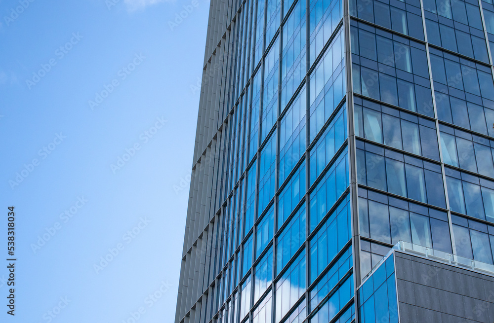 Modern glass facade. Bottom view of a building in the business district. Glass facade of an office building background Modern glass facade. Bottom view of a building in the business district. Glass facade of an office building background
