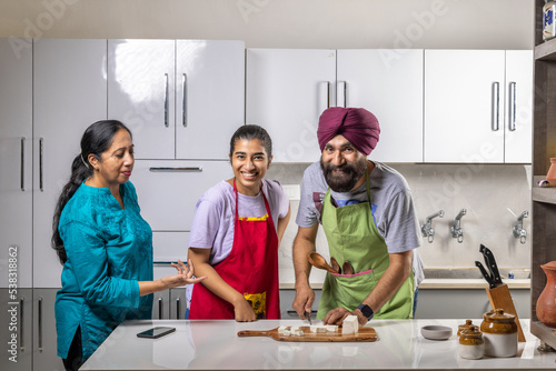 sikh family in a kitchen, working and enjoying together