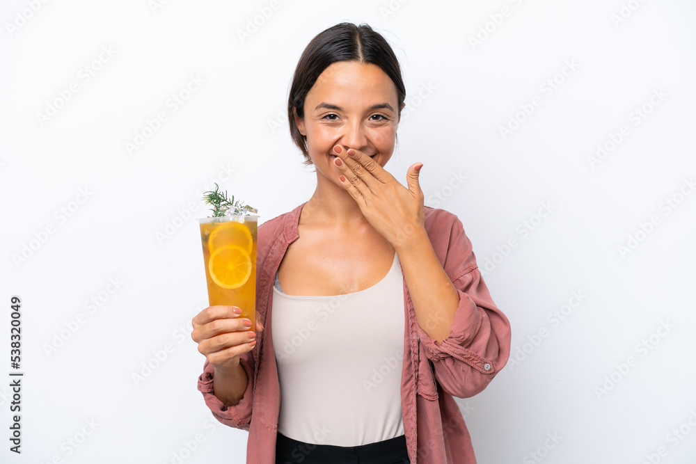 Young hispanic woman holding a cocktail isolated on white background happy and smiling covering mouth with hand Young hispanic woman holding a cocktail isolated on white background happy and smiling covering mouth with hand
