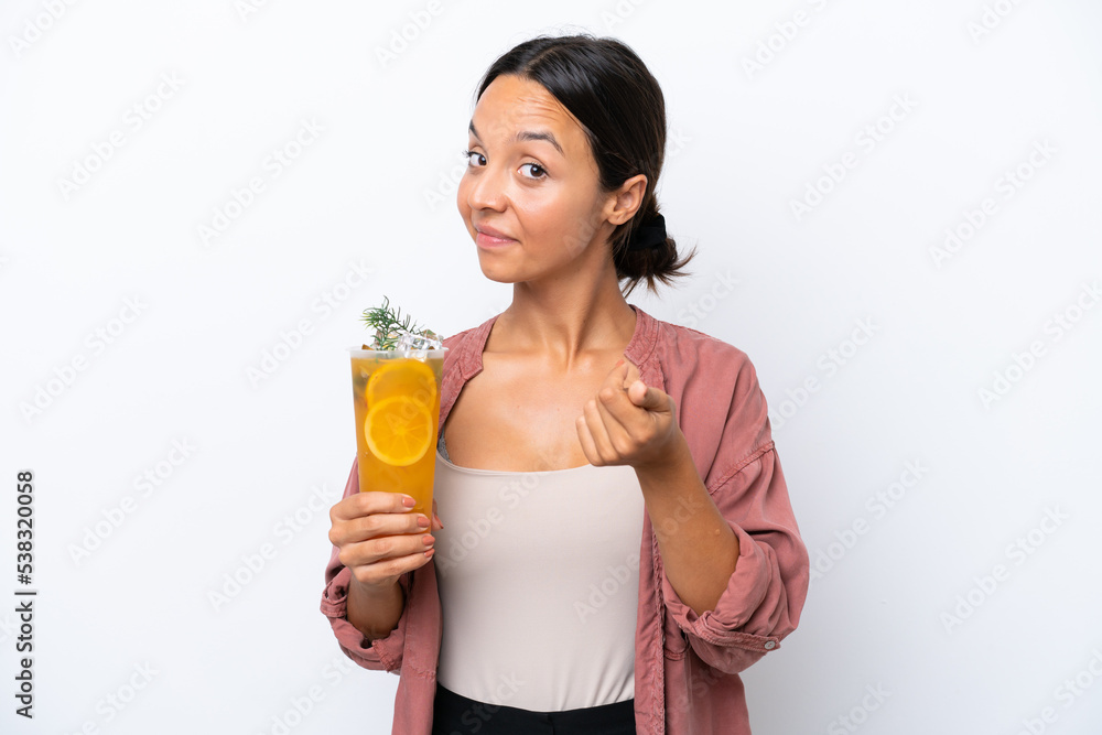 Young hispanic woman holding a cocktail isolated on white background making money gesture Young hispanic woman holding a cocktail isolated on white background making money gesture