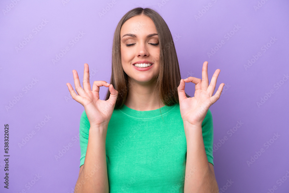 Young caucasian woman isolated on purple background in zen pose Young caucasian woman isolated on purple background in zen pose