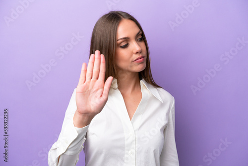 Canvas Print Young caucasian woman isolated on purple background making stop gesture and disa