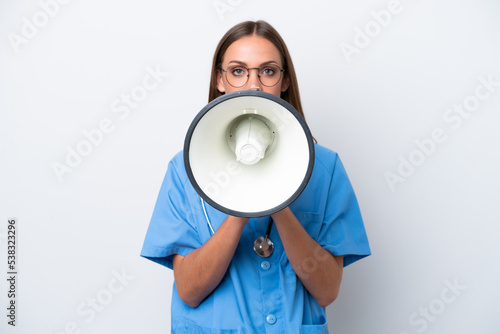 Young nurse caucasian woman isolated on white background shouting through a megaphone