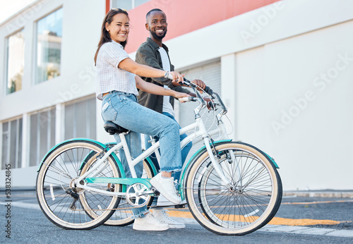 Fototapeta Naklejka Na Ścianę i Meble -  Happy couple, bicycle and city street travel for exercise, fun or adventure outdoor. Black and asian tourist man and woman cycling for carbon footprint on bike in urban town traveling in South Africa