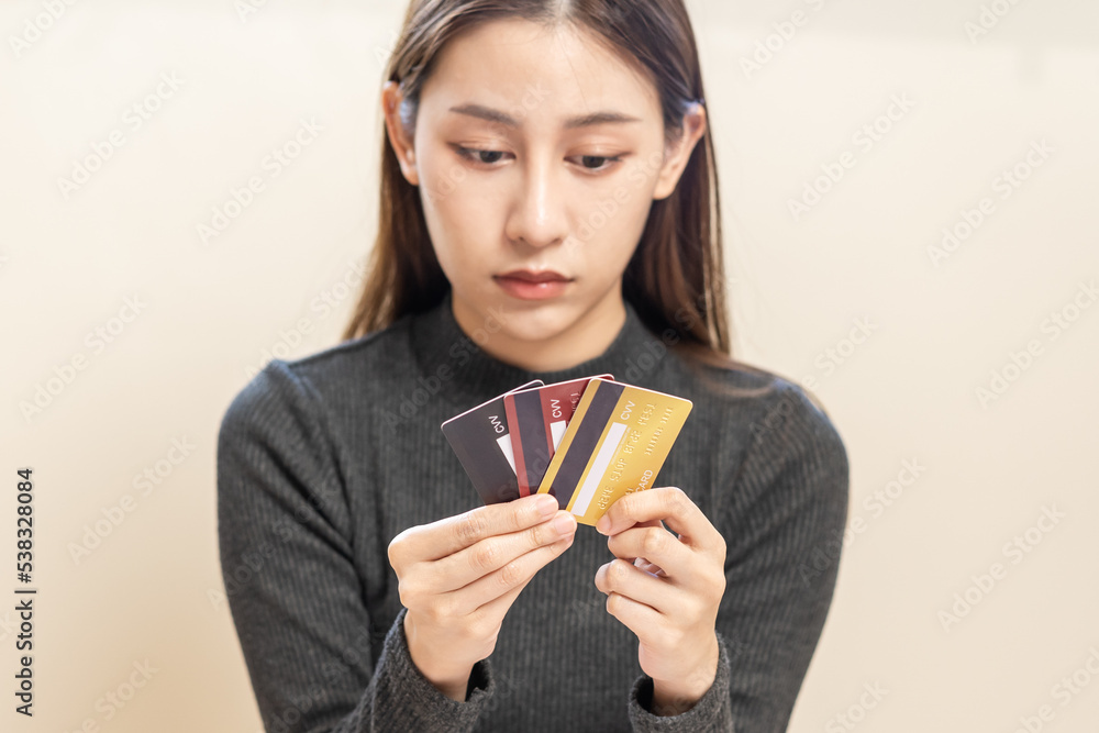 Financial owe, hand of asian woman, girl hand in holding, looking at many credit card, stressed by calculate expense from bill, no money to pay, mortgage or loan. Debt, bankruptcy or bankrupt. Financial owe, hand of asian woman, girl hand in holding, looking at many credit card, stressed by calculate expense from bill, no money to pay, mortgage or loan. Debt, bankruptcy or bankrupt.