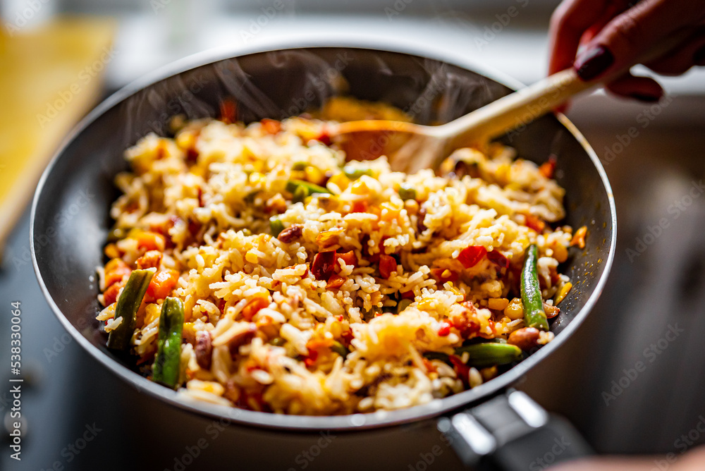 cooking tasty rice and vegetable mix with corn, pea, beans in pan on kitchen cooking tasty rice and vegetable mix with corn, pea, beans in pan on kitchen