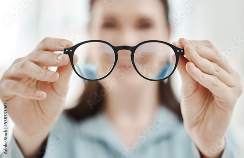Eyes, vision and glasses with the hands of a woman optometrist holding spectacles during an eye test or exam. Frame, medical and insurance with a female optician showing prescription eyewear