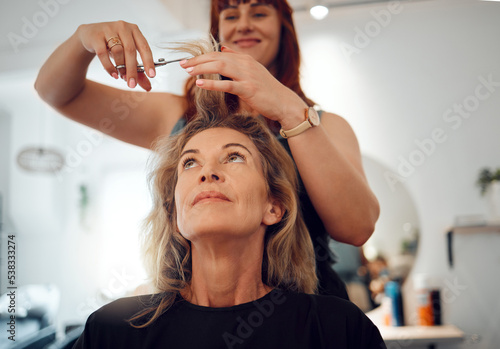 Haircut and hairdresser styling the hair of client in salon for makeover, beauty and hair care. Hairstylist, senior woman customer in retirement and cosmetic service or treatment at parlor in Canada.