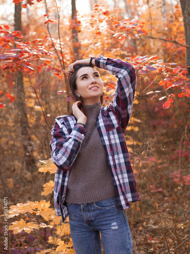 Young happy woman posing in autumn forest