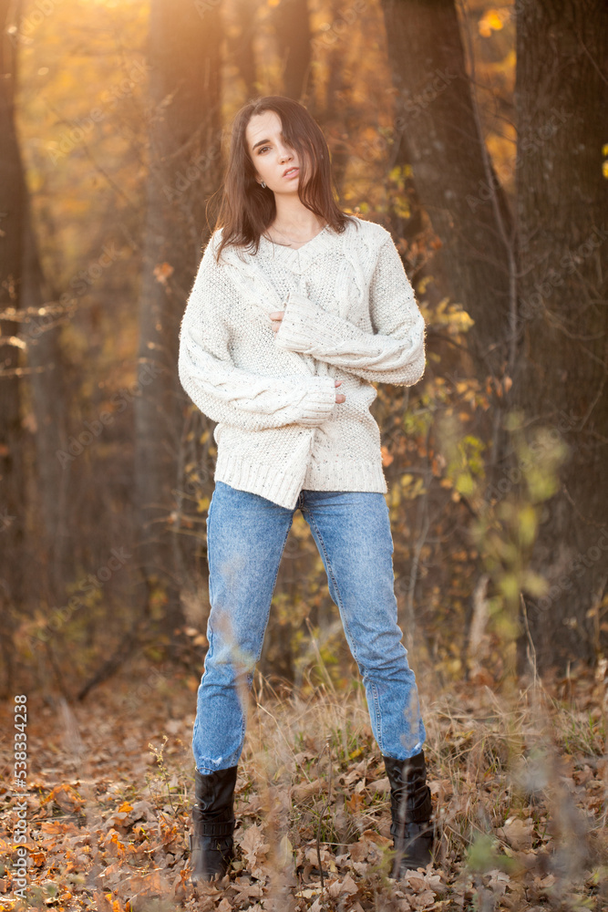 Young woman in whte sweater posing in yellow autumn forest Young woman in whte sweater posing in yellow autumn forest