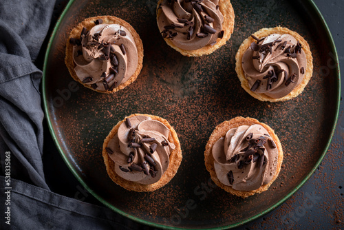 Sweet mini tartlets with chocolate cream and sprinkles.
