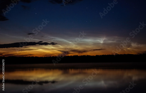 Evening by the lake with noctilucent clouds on a summer night