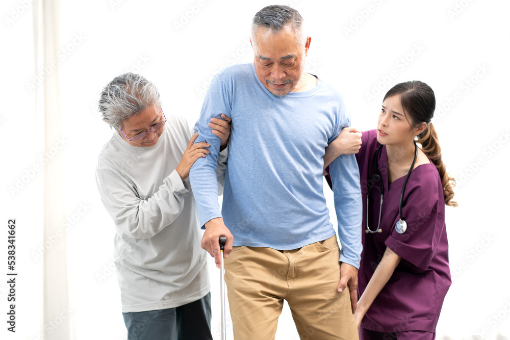 Elderly man patient holding stick walking with support from senior woman and young nurse. Caregiver helps old man has illness recovery and standing at nursing home. Senior couple in rehabilitation. Elderly man patient holding stick walking with support from senior woman and young nurse. Caregiver helps old man has illness recovery and standing at nursing home. Senior couple in rehabilitation.