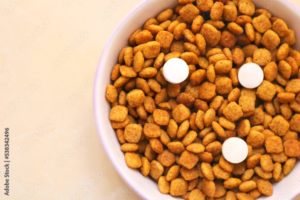 Cat food with three pills in a bowl on the floor. Vitamins for cats. Cat treatment Cat food with three pills in a bowl on the floor. Vitamins for cats. Cat treatment