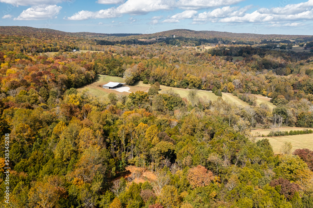 Aerial view, of colorful autumn mountain landscape, with a valley barn and farm land in Alabama U.S.A.